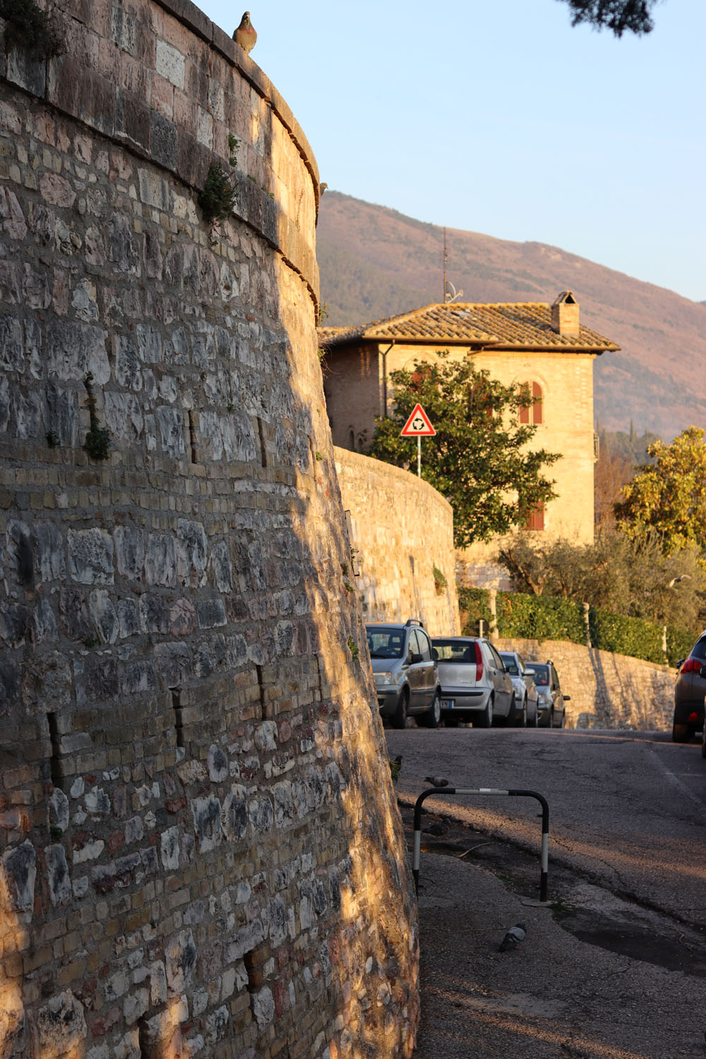 Cars parked by a stone wall Cars parked by a stone wall