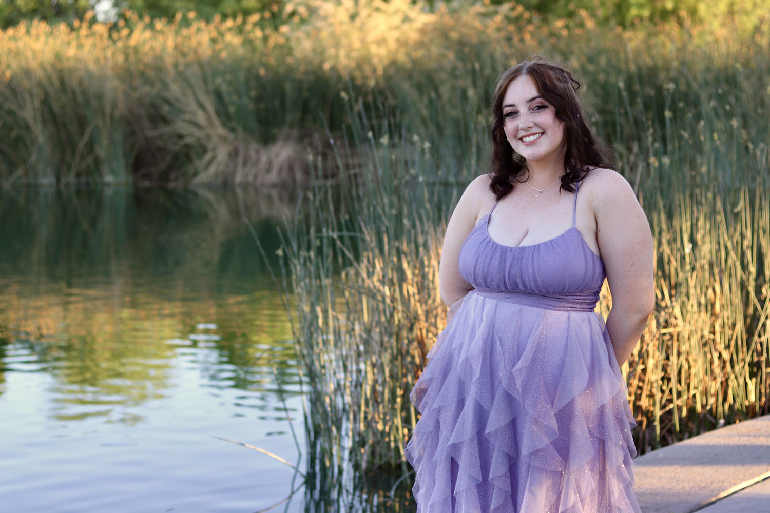 Young girl ready for prom in front of a pond Young girl ready for prom in front of a pond